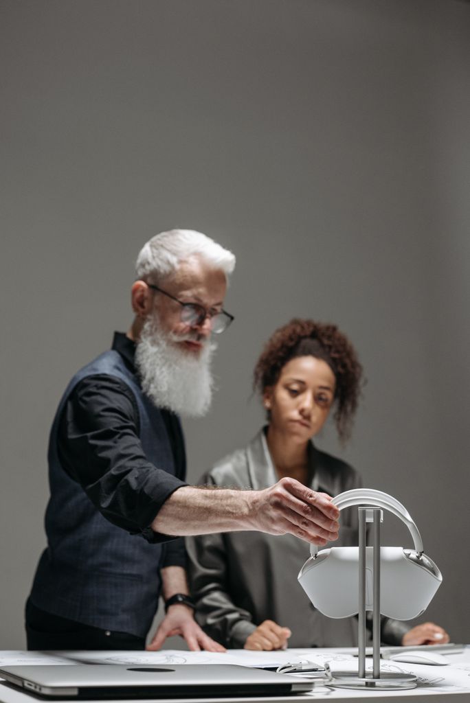 Two professionals reviewing wireless headphones during a studio meeting.